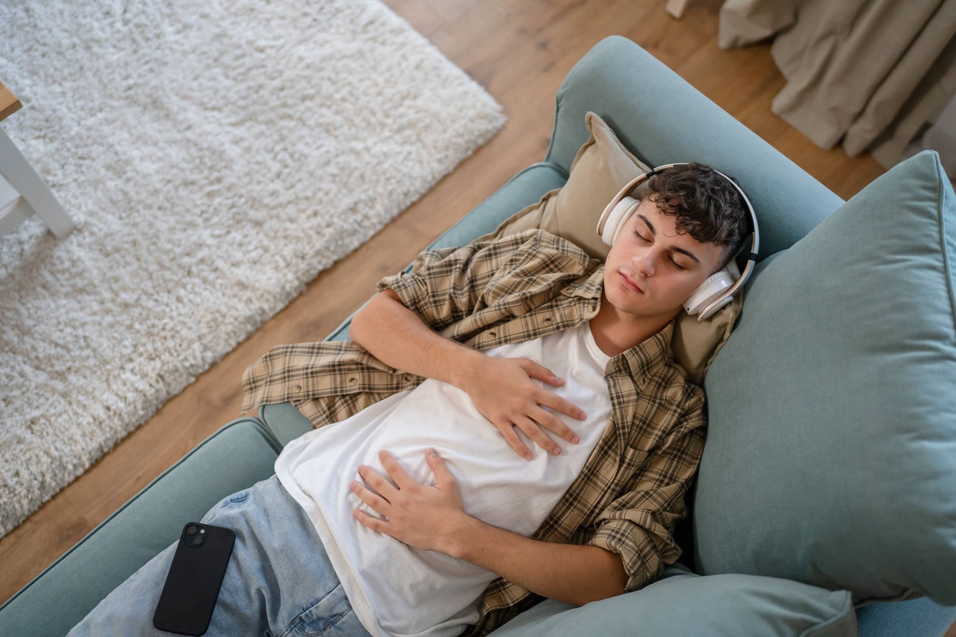 Junger Mann entspannt mit Musik auf dem Sofa | Weingut Bassermann Jordan